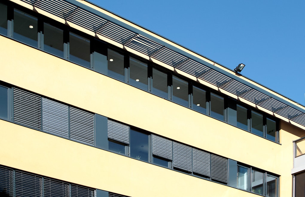 Wohnhausfront mit geöffnetem und geschlossenem Sonnenschutz