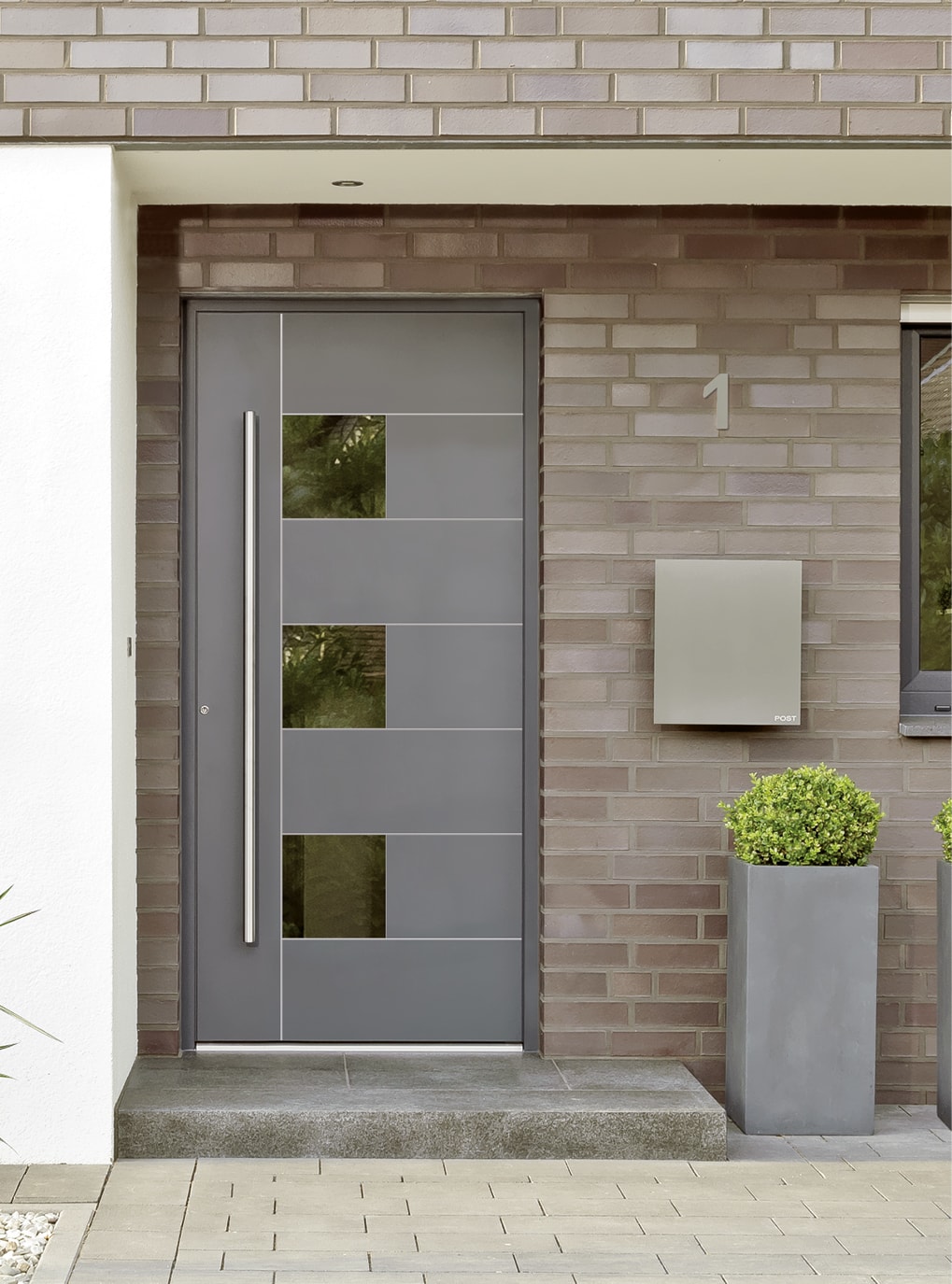 Eingangsbereich von einem Haus in Backsteinoptik mit Strussnig Premium-Alu-Haustüre in Detailansicht