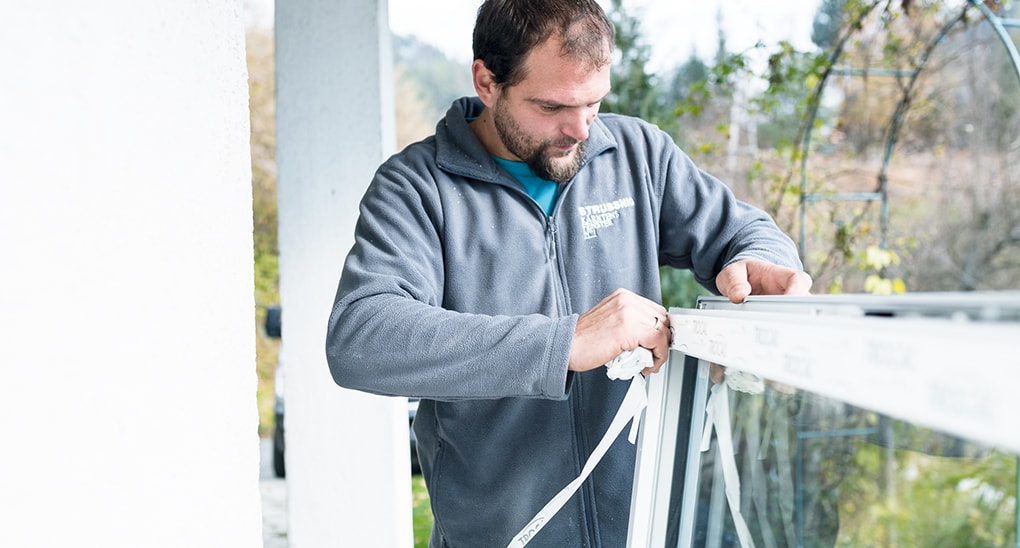 Strussnig-Mitarbeiter bereitet Fenster durch Entfernen der Schutzfolie auf Montage vor