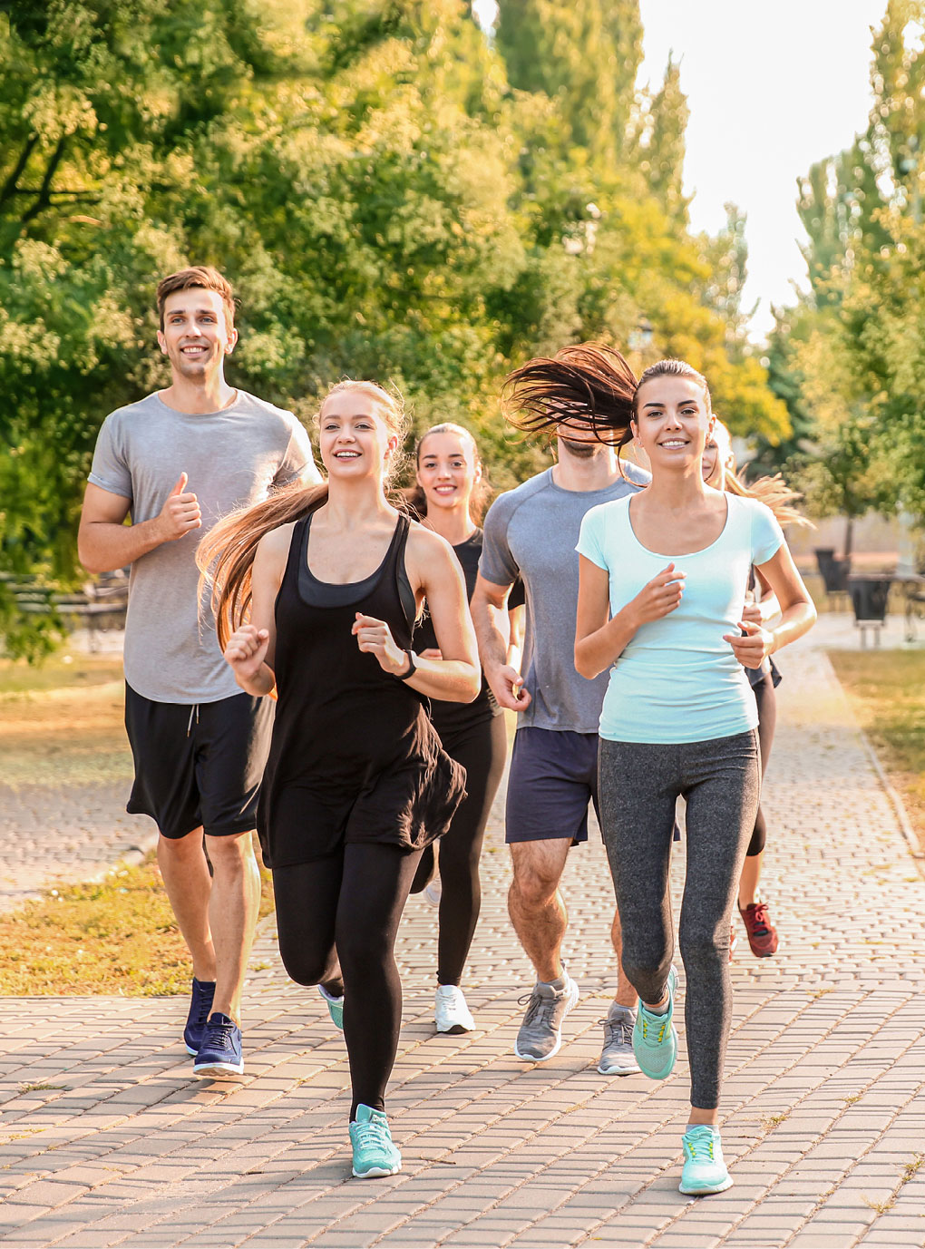 Eine Gruppe junger Menschen läuft in einem Park.