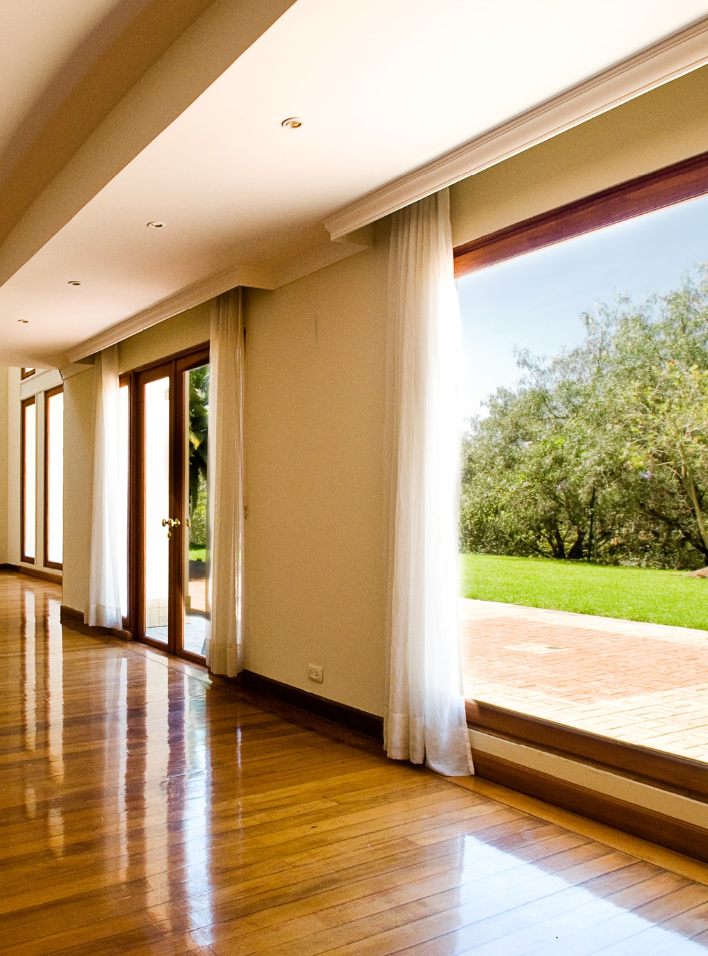 Innovato+ Holz-Alu Fenster von Strussnig mit weißen Gardinen von leerem Raum mit Parkettboden