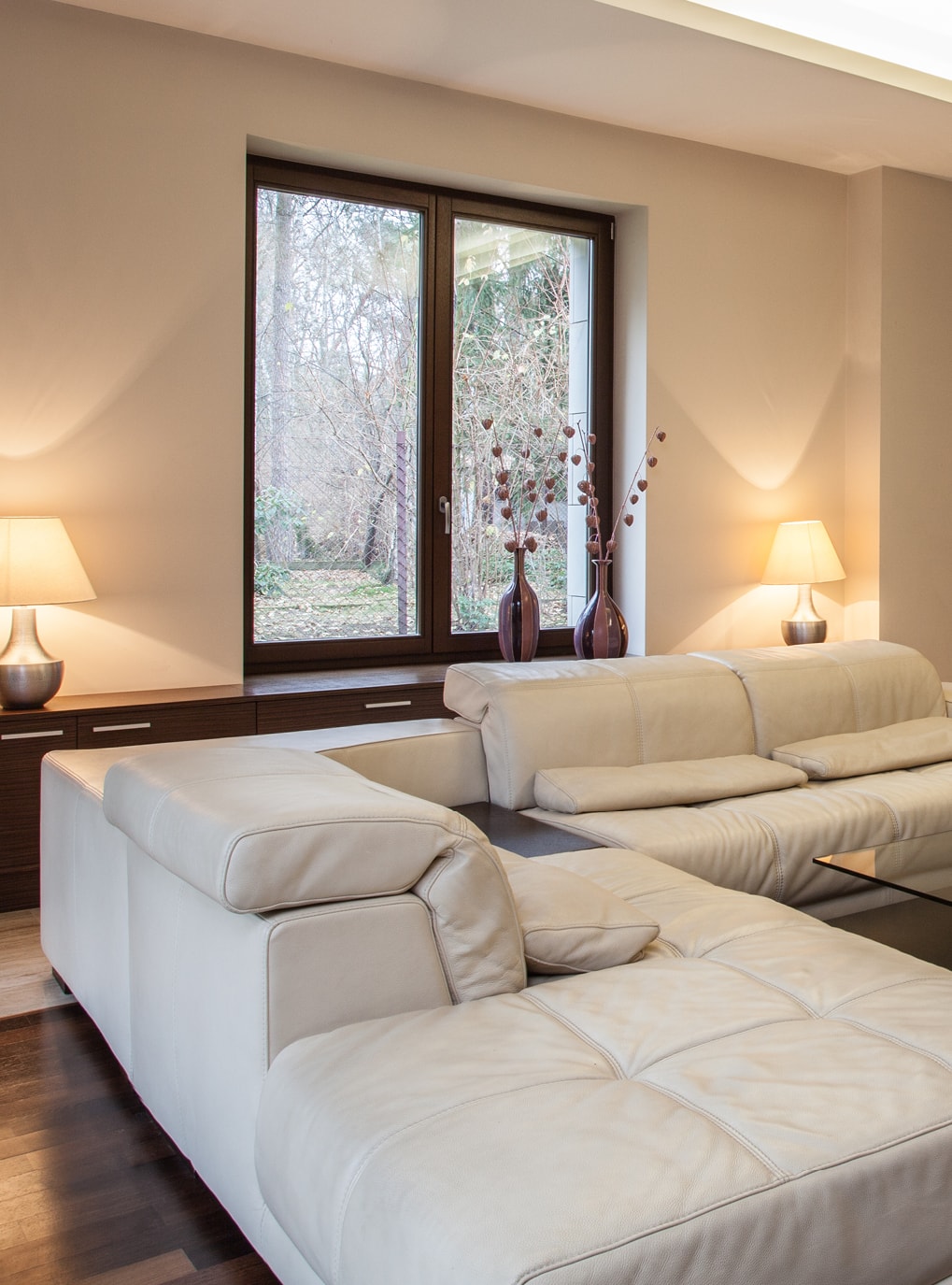 Innovato+ Holz-Alu Fenster von Strussnig in weiß gehaltenem Wohnbereich mit Sofa