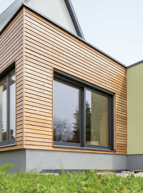 Strussnig-Fenster mit hochgezogenen Rollläden an hölzerner Hausfront